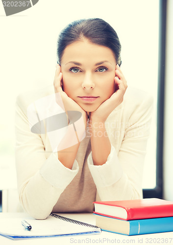 Image of bored and tired woman behid the table