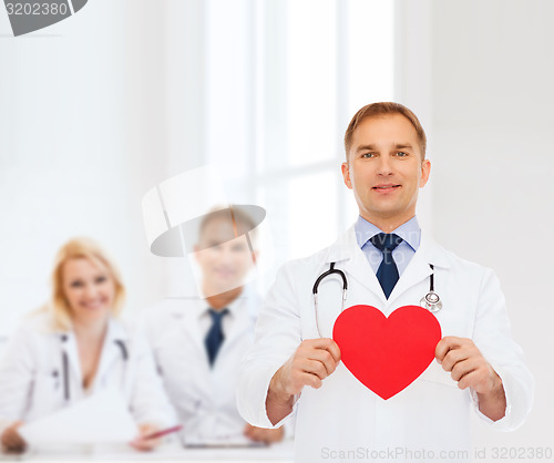 Image of smiling male doctor with red heart and stethoscope