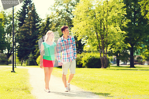 Image of smiling couple walking in park