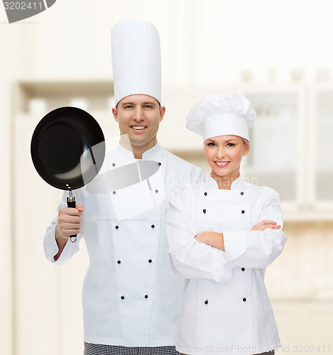 Image of happy male chef cook holding frying pan