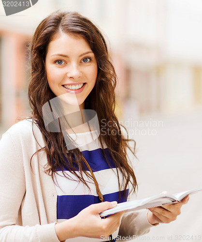 Image of girl looking into tourist book in the city