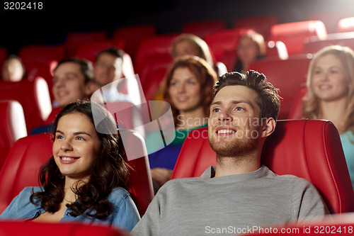 Image of happy friends watching movie in theater