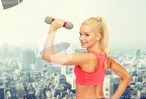 Image of young sporty woman with light dumbbell