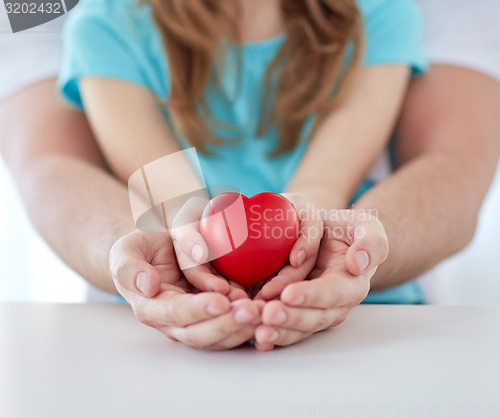 Image of close up of man and girl holding red heart shape