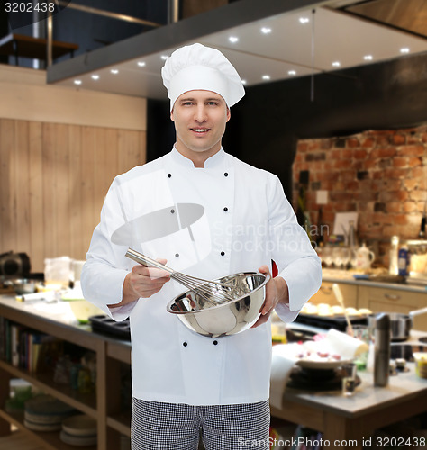 Image of happy male chef cook whipping something with whisk