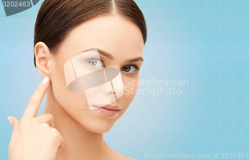 Image of face of beautiful woman touching her ear