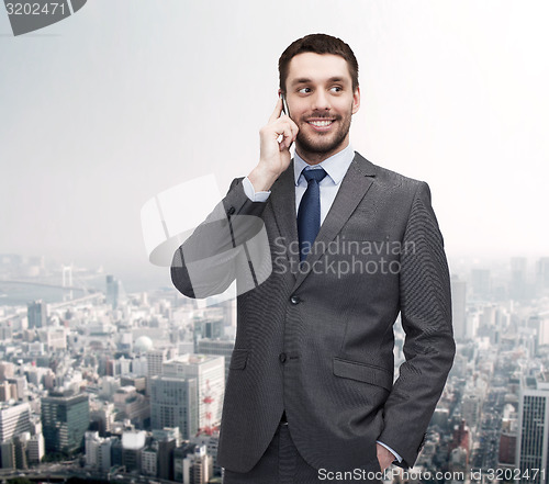 Image of young smiling businessman with smartphone