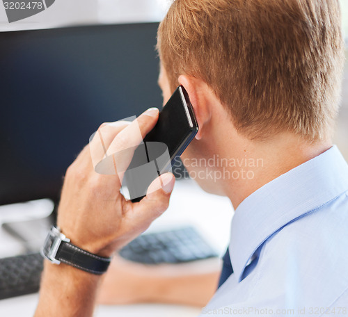 Image of businessman with smartphone in office
