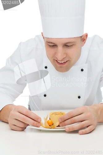 Image of happy male chef cook decorating dessert