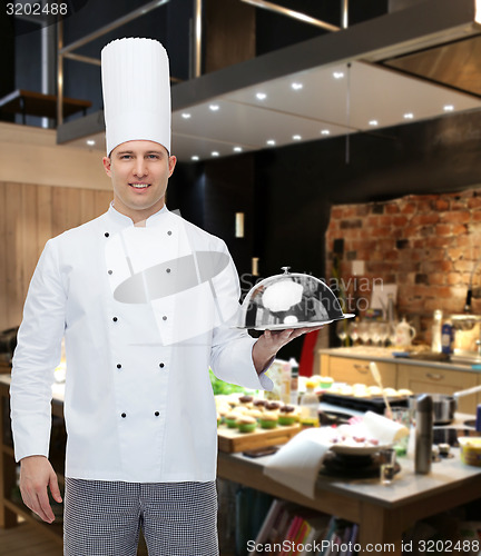 Image of happy male chef cook holding cloche