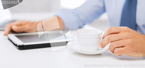 Image of businessman with tablet pc and coffee in office