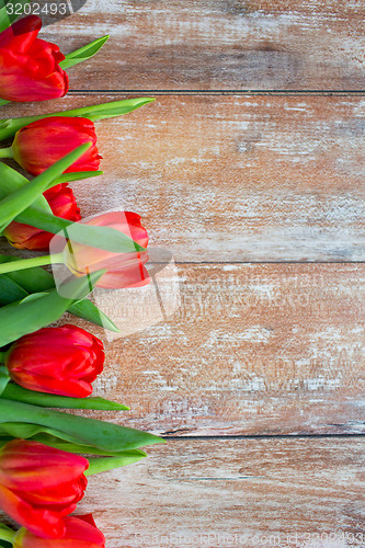 Image of close up of red tulips on wooden background