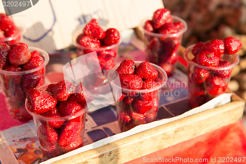 Image of strawberry in plastic cups at street market