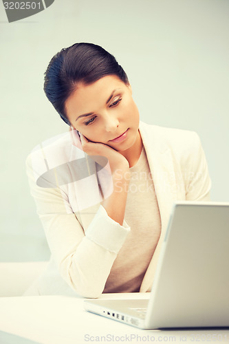 Image of pensive woman with laptop computer