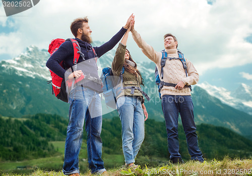 Image of group of smiling friends with backpacks hiking