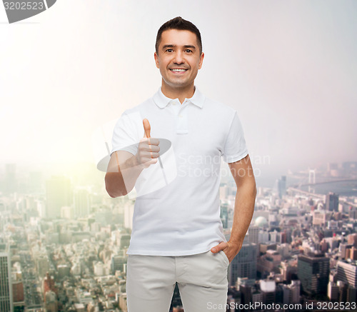 Image of smiling man showing thumbs up over city background