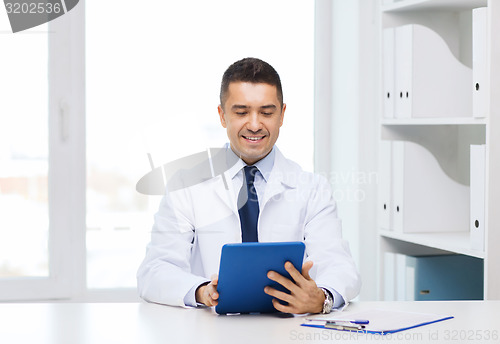 Image of smiling male doctor in white coat with tablet pc
