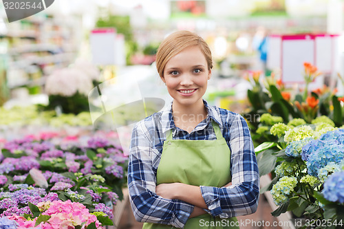 Image of happy woman with flowers in greenhouse