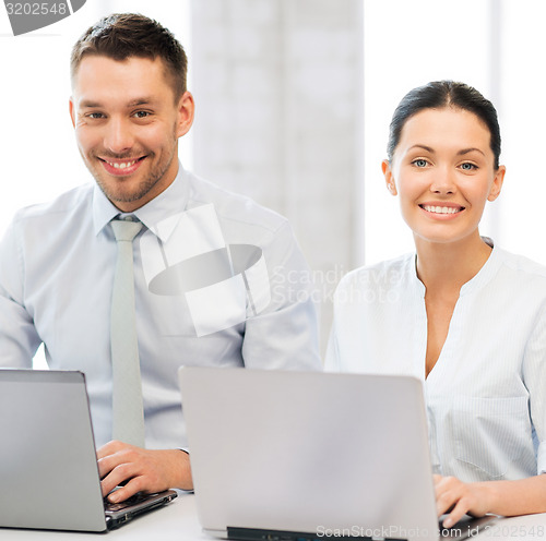 Image of group of people working with laptops in office