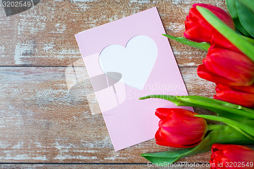 Image of close up of tulips and greeting card with heart