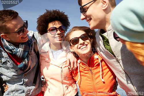 Image of smiling friends in sunglasses laughing on street