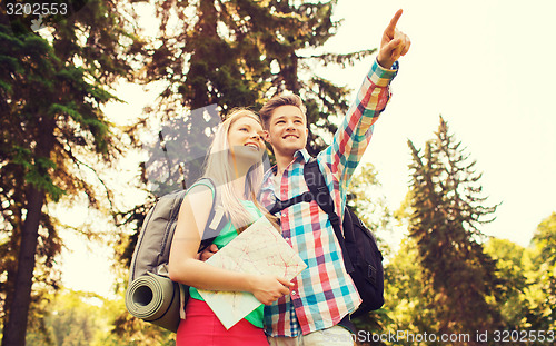 Image of smiling couple with map and backpack in nature