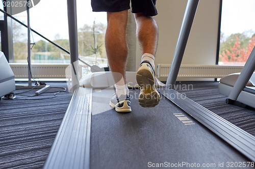 Image of close up of man legs walking on treadmill in gym