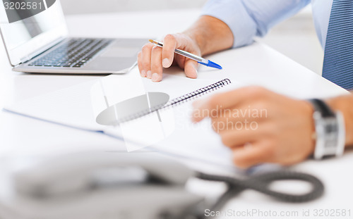 Image of businessman writing in notebook