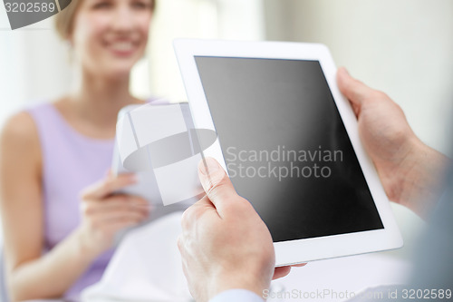 Image of close up of couple with tablet pc at restaurant