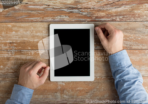 Image of close up of male hands to tablet pc on table