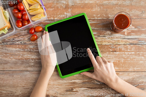 Image of close up of woman with tablet pc food on table