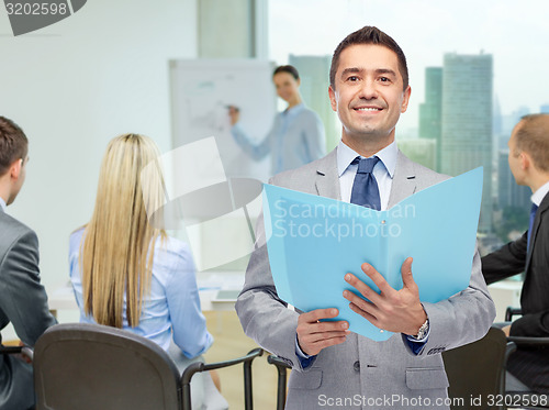 Image of happy businessman with open folder