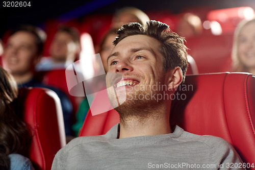 Image of happy young man watching movie in theater