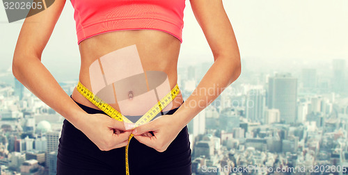 Image of close up of female hands measuring waist