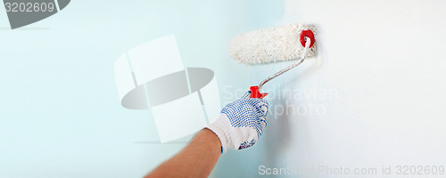 Image of close up of male in gloves painting wall