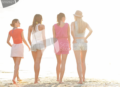 Image of group of young women walking on beach