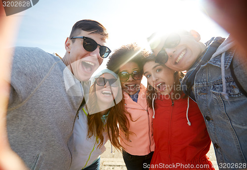 Image of happy laughing friends taking selfie