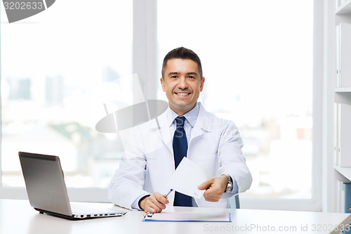 Image of happy doctor with prescription and laptop