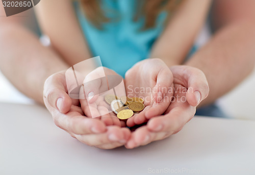 Image of close up of family hands holding euro money coins