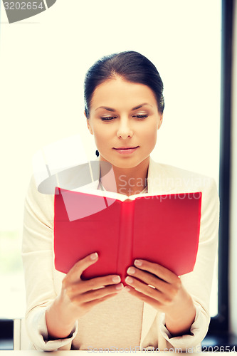 Image of calm and serious woman with book