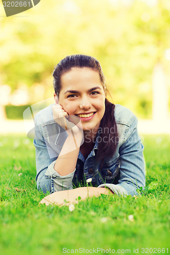 Image of smiling young girl lying on grass