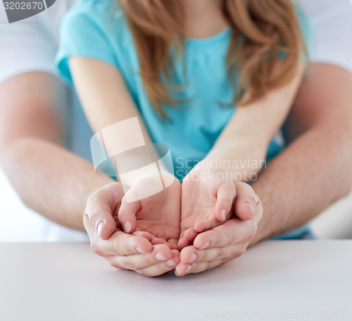 Image of close up of man and girl with cupped hands at home