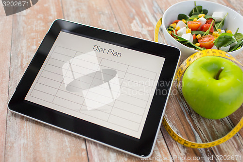 Image of close up of diet plan on tablet pc and food