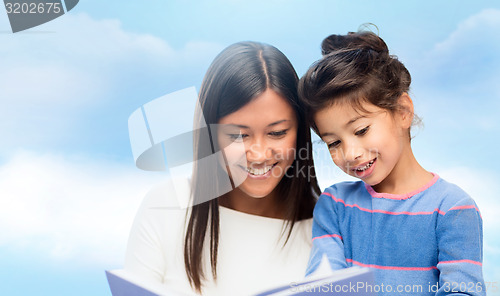 Image of happy mother and daughter reading book