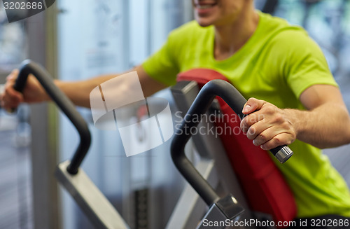 Image of close up of smiling man exercising on gym machine