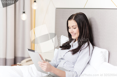 Image of happy businesswoman with tablet pc in hotel room