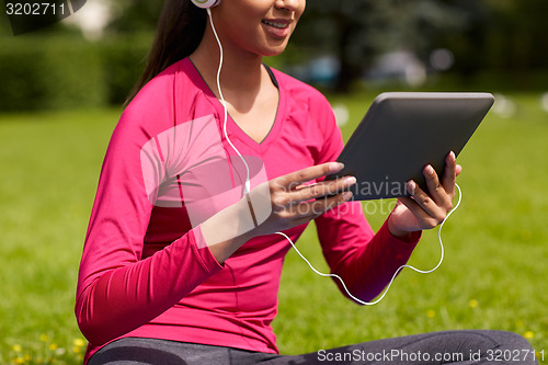 Image of close up of smiling woman with tablet pc outdoors