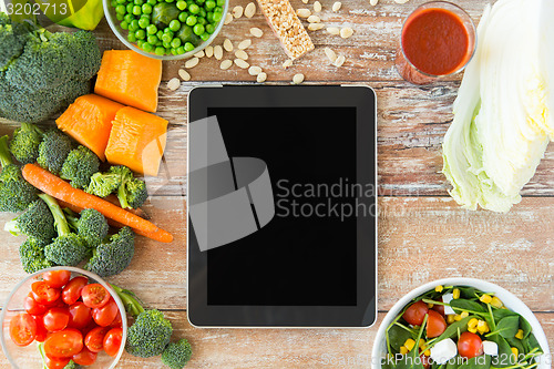 Image of close up of blank tablet pc screen and vegetables