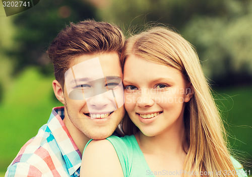 Image of smiling couple hugging in park