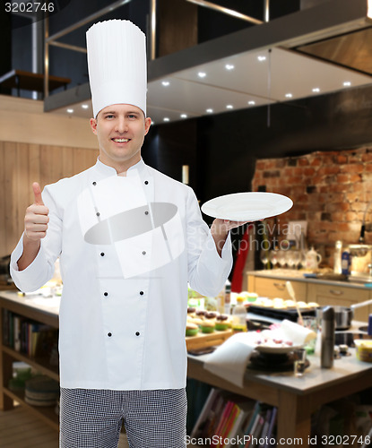 Image of happy male chef cook showing thumbs up and plate